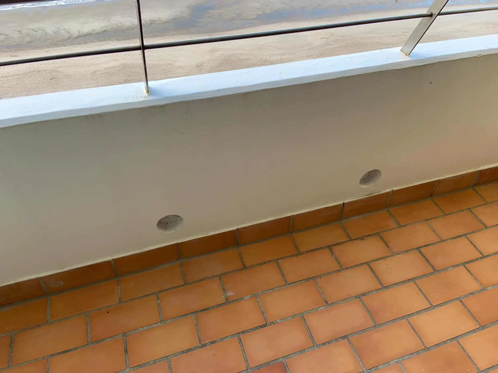 Balkonbrüstung mit zwei eingelassenen Sensoren, dahinter die Dünen