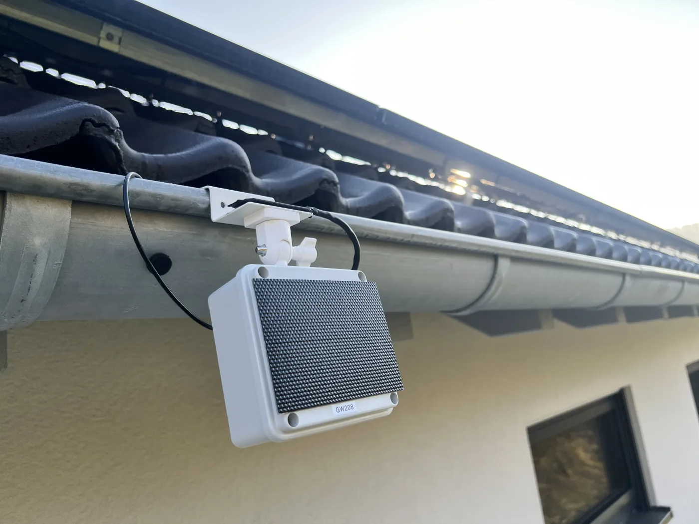 Rinnensensor mit Solarmodul an der Dachrinne eines Wohnhauses