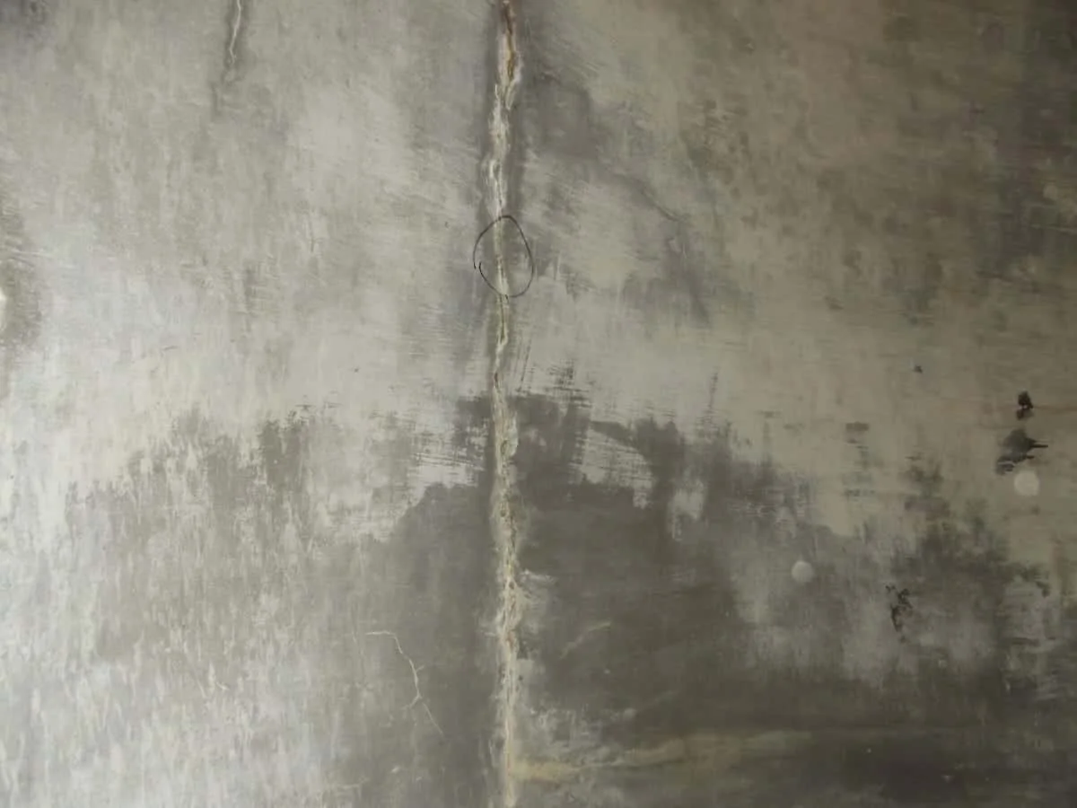 Crack in a concrete surface, marked and with lime efflorescence