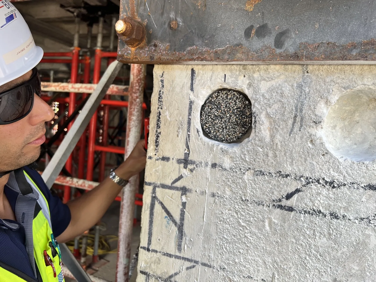 Mitarbeiter von Infrasolute inspiziert ein Brückenbauteil vor Ort