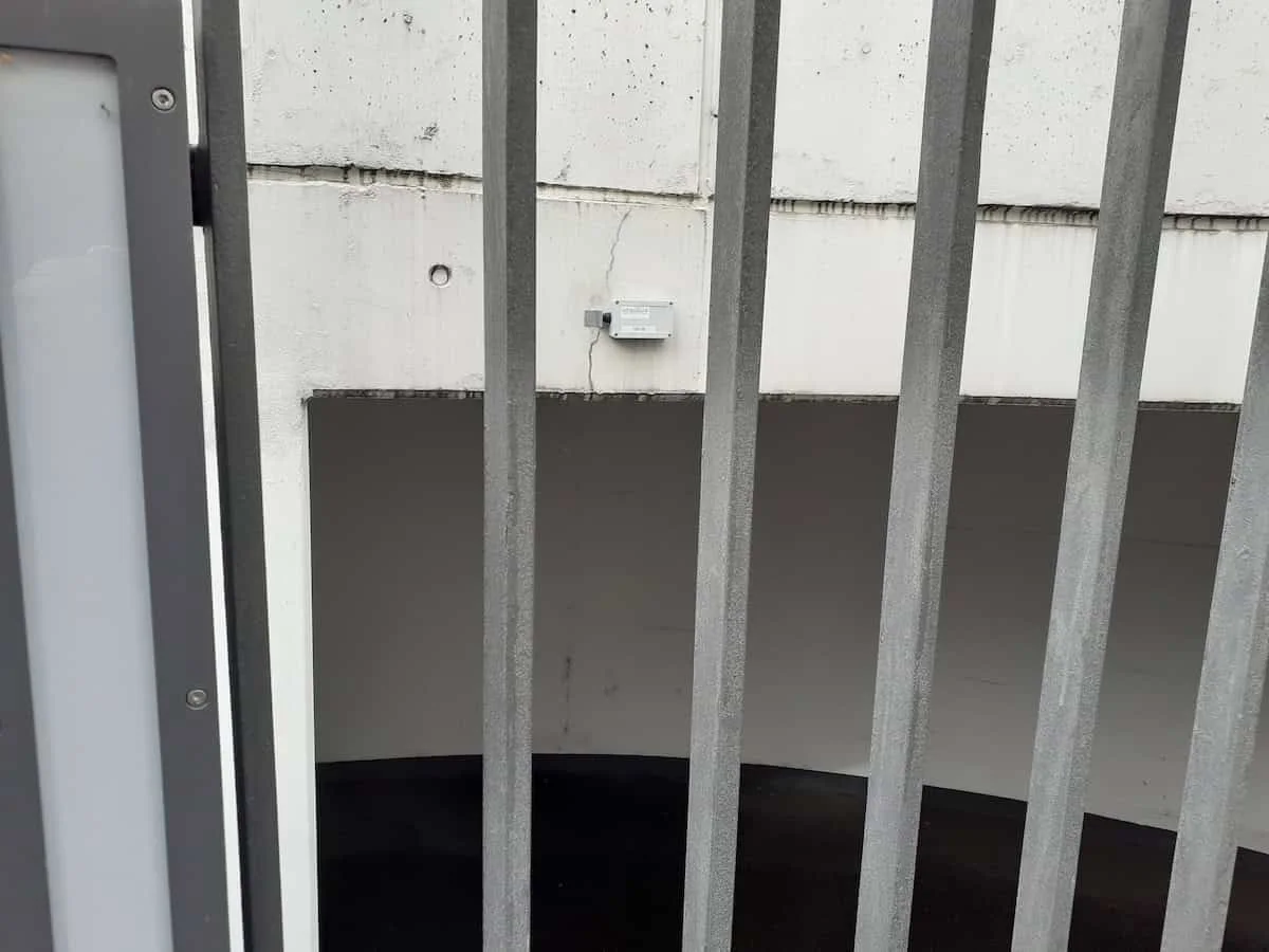 Sensor an der Betonwand über der Einfahrt zur Tiefgarage, der Riss läuft zur Montagestelle