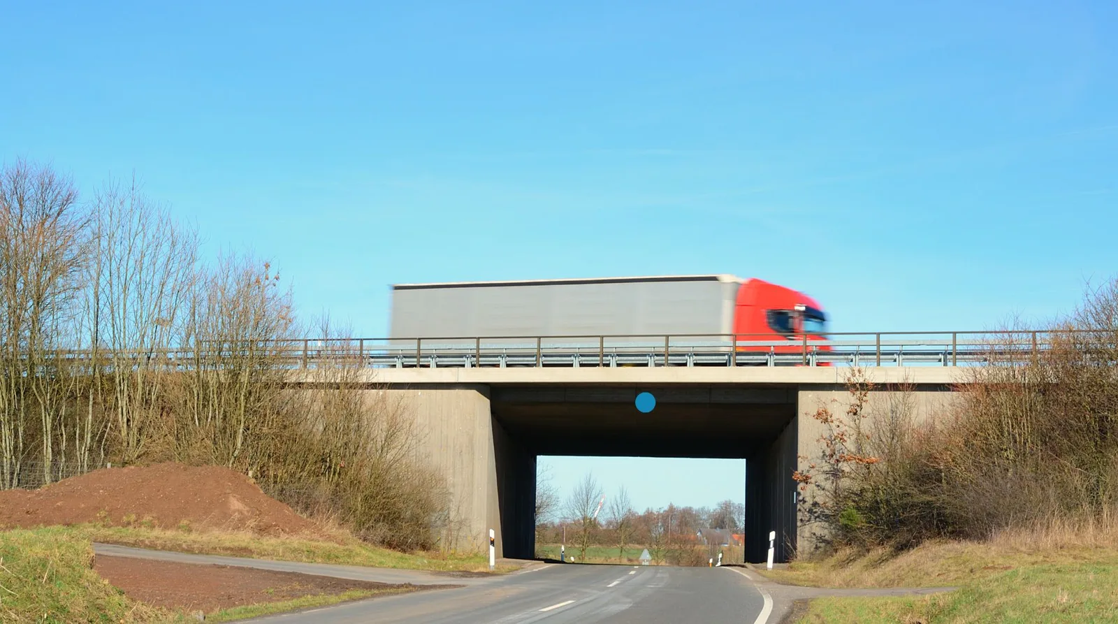 Lastwagen auf einer Autobahnüberführung, am Überbau ist die Messstelle markiert